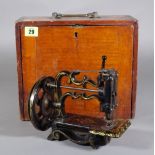 A mahogany cased miniature sewing machine.