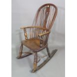 A 19th century ash and elm stick back rocking open armchair on ring turned tapering supports.