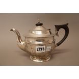 A silver teapot, of circular form, having black fittings, London 1935, gross weight 441 gms.