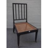 A Regency ebonised side chair with bobbin turned back, legs and cane seat, 51cm wide x 95cm high.