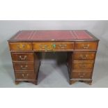 A 20th century mahogany pedestal desk with eight drawers around the knee,