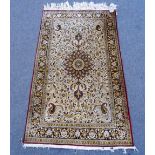 A silk rug, sun bleached gold white main field with lobed circular medallion, boteh spandrels,