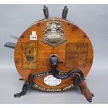 A Kent's patent knife cleaner, early 20th century, circular oak cased in a cast iron frame.