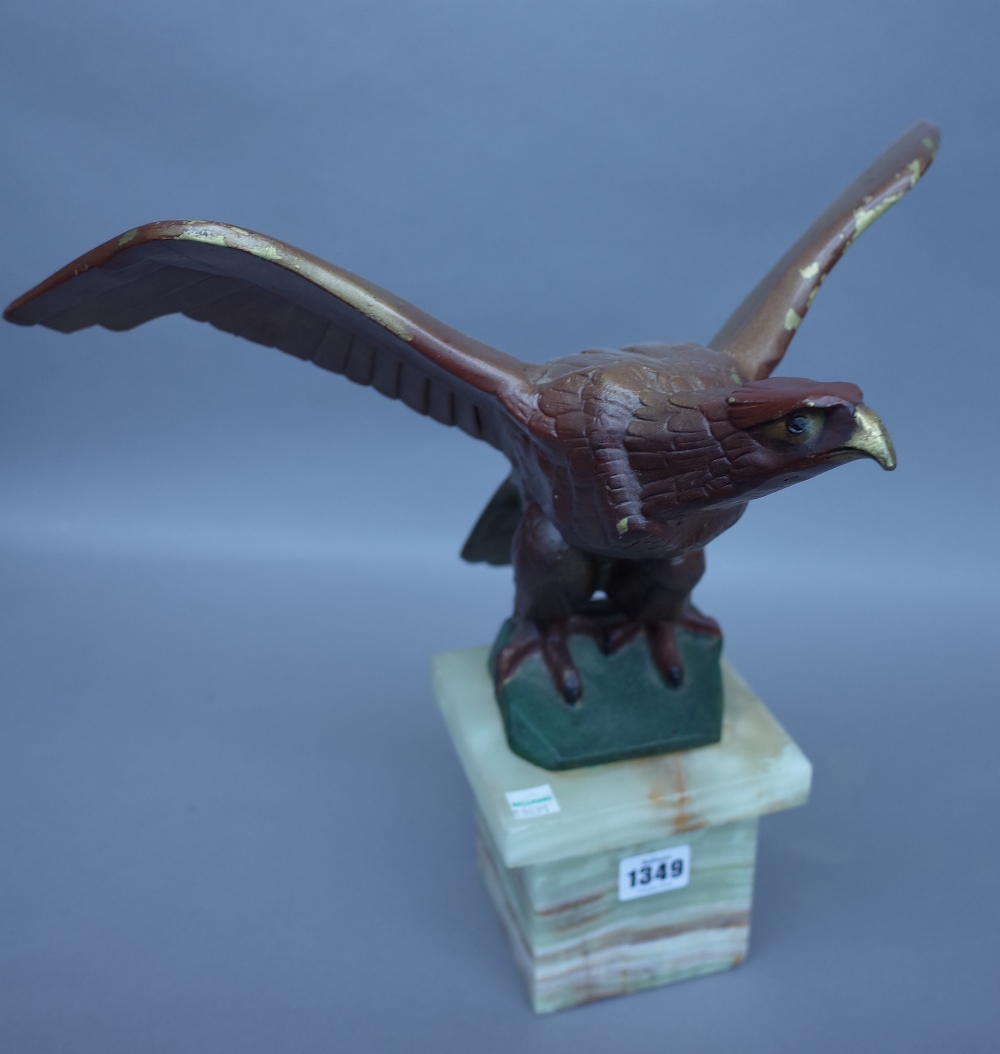 A polychrome painted bronze eagle, circa 1930, signed 'M. Decoux' on an onyx plinth, 35.