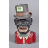An early 20th century cast iron musical money box in the form of a golliwog.