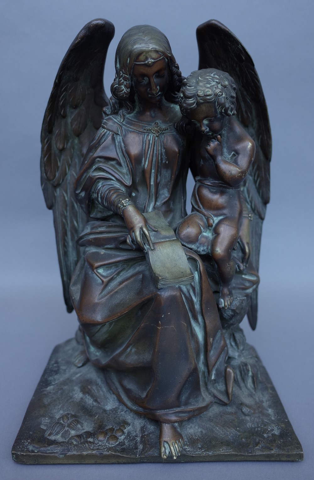 An early 20th century bronze figure group depicting The Archangel Gabriel with a putto on a