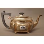 A silver teapot, of fluted bombe form, raised on four bun feet with black fittings, Chester 1923,