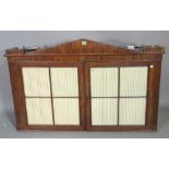 An early 19th century continental mahogany hanging two door cabinet, with architectural cornice,