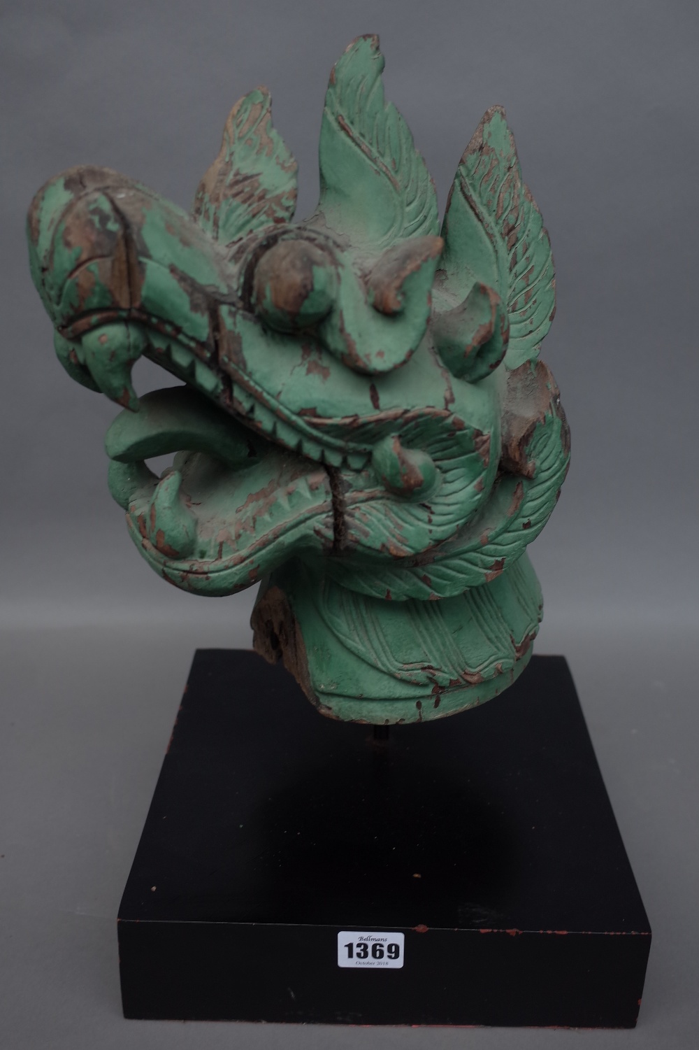 A green painted carved wooden Chinese dragon head, distressed,