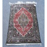 A silk Ghom rug Central Persia, stepped central medallion within pink red stepped field,