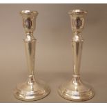 A pair of silver table candlesticks, each raised on a circular base, (loaded), modern, height 18cm.