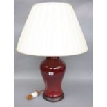 A Chinese porcelain vase table lamp, sang de boeuf, baluster ground with a cream silk pleated shade,
