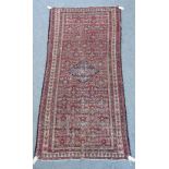 A Senneh rug, Persian, the madder field with a central indigo diamond,