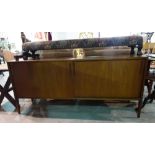 A 20th century teak sideboard with sliding panel doors on tapering square supports,