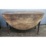 A mid 18th century mahogany drop leaf dining table, the hinged oval top, on club legs and pad feet,