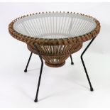A retro circular glass top wicker low centre table, on splayed metal legs,