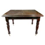 An Edwardian mahogany extending dining table, the moulded rectangular top with extra leaf,