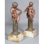 A pair of early 20th century spelter cherubs on columns, 30cm high, (a.f), (2).