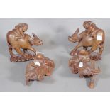 Four Chinese wood figures of boys seated on water buffaloes, 20th century.