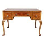 A reproduction early 18th century style walnut bowfront three drawer writing table, 111cm wide,