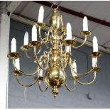 A pair of reproduction Dutch style brass twelve light chandeliers, with scrolled branches,