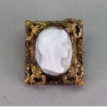 A white agate cameo brooch, carved as a female profile within a gold decorative framed,