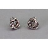 A pair of contemporary ear clips, detailed 750, of textured and polished entwined scroll design,