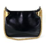 Gucci; A vintage black leather handbag with gilt metal shoulders and gilt metal shoulder strap,