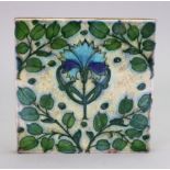 A William de Morgan style tile, late 19th century, painted with a central carnation, 15cm square.