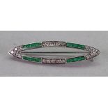 A white gold, diamond and emerald brooch,
