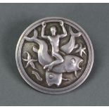 A Georg Jensen silver brooch, the circular design depicting a man riding a fish,