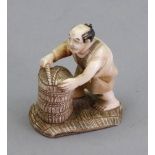 A Japanese ivory okimono, carved as a man standing on a mat holding a basket, 6cm high.