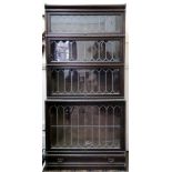 An oak four-tier Globe Wernicke bookcase, enclosed by leaded glazed up and over doors,