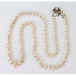 A graduated cultured pearl necklace, on cultured pearl and paste cluster clip.