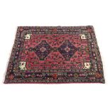 A North West Persian rug, with two lozenges, on a pink ground, 145cm x 102cm.