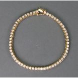 A gold and diamond tennis bracelet, the 60 stones approximately. 0.