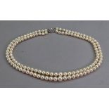 A two-row graduated cultured pearl necklace on a white gold and eight-cut and baguette cut diamond