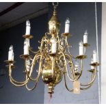 A Dutch style brass fifteen light chandelier, with scrolled branches, arranged in two rows,