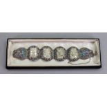 A carved jade panel link bracelet, the four jade panels carved and pierced in varied designs,