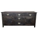 An oak low dresser, 18th century, of panelled construction,