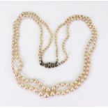 A two-row graduated cultured pearl necklace on white gold and small rose-cut diamond clip,