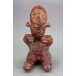 A Pre-Columbian style seated figure, with mottled decoration, 28cm high.