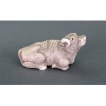 A Japanese ivory netsuke of a recumbent ox, carved looking upwards, 7cm length, signed 'Masanno'.