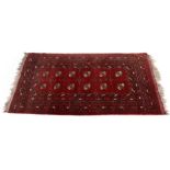 An Afgan rug, with two rows of quartered guls, on a red ground, 200cm x 104cm and a Gelim rug,