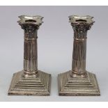 A pair of George III style silver dwarf Corinthian column candlesticks, James Jay, London 1901,