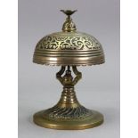 A William Tonks & Son brass table bell, foliate cast, with push action and spreading circular base,