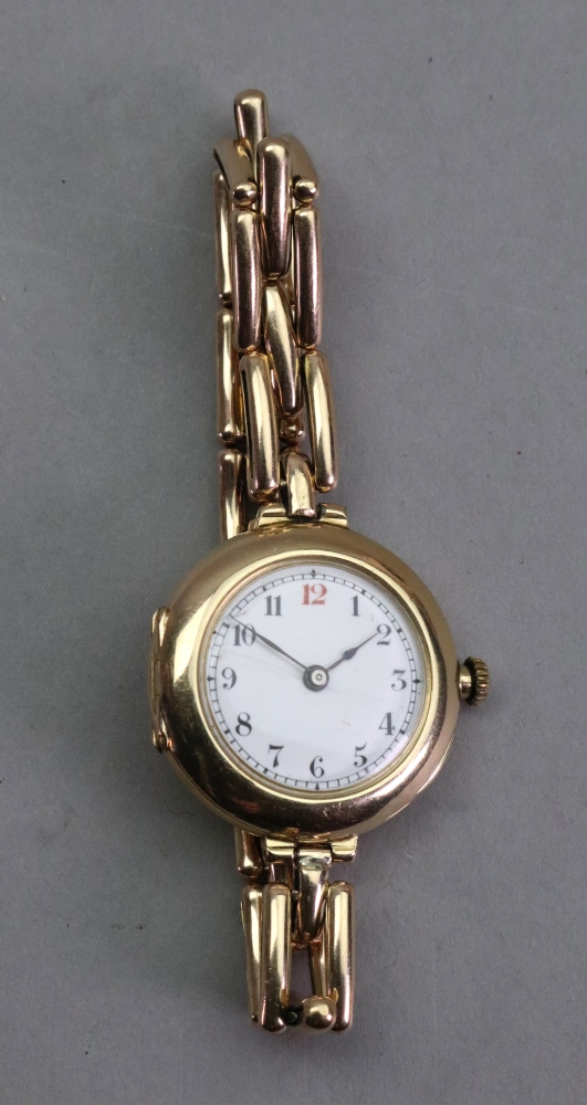 A lady's 15ct gold manual wind wristwatch, the white enamel dial with Arabic numerals,