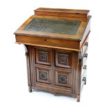 An Edwardian carved and panelled oak Davenport, with raised stationery compartment back,