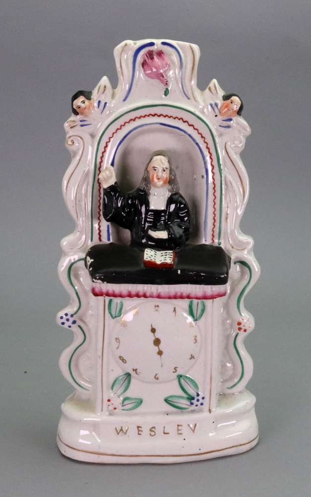 A Victorian Staffordshire pottery figure of Wesley preaching with clock face, 28cm high.
