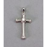 A white gold and diamond cross pendant, centred by a round brilliant cut diamond,